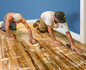 Two men sanding floors