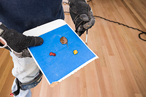 A man mixing stain colors to achieve the correct tone to match existing floors